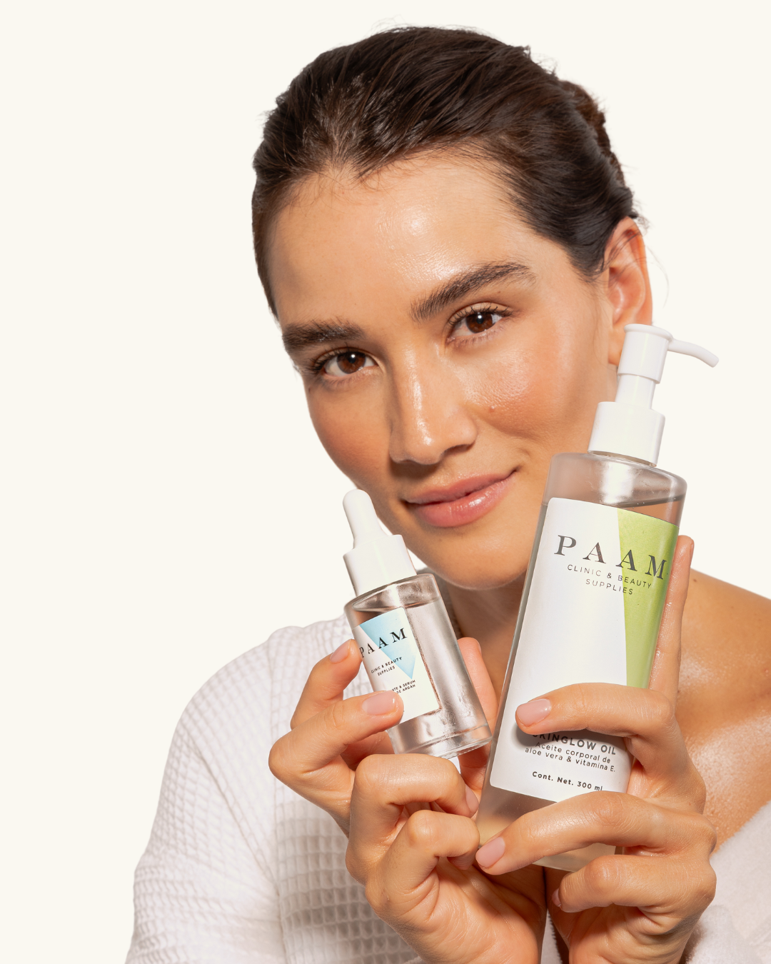 Modelo sosteniendo SkinGlow Oil y desmaquillante de argán PAAM